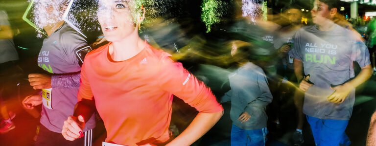 Des athlètes courent la nuit sur une route