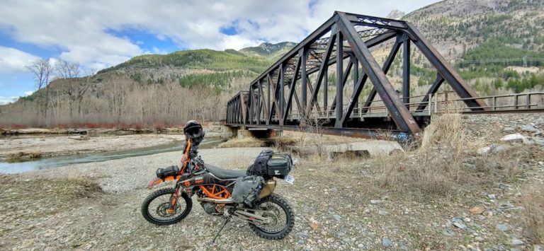 motorcycle in front of a train bridge across the Elk River