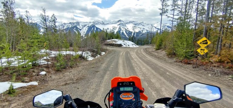 motorcycle going down a dirt road towards mountains