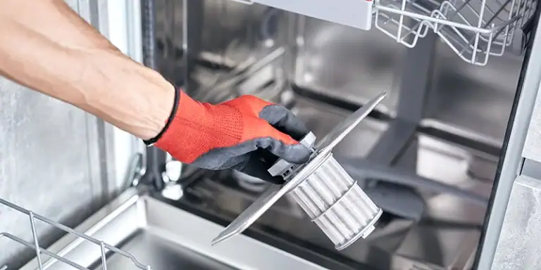 dishwasher - Simple Care for Your Dishwasher - person holding filter removed from dishwasher