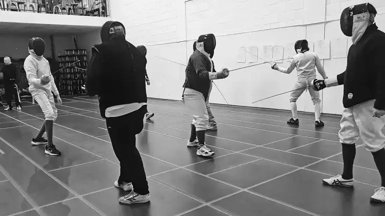A group of fencers receiving coach training