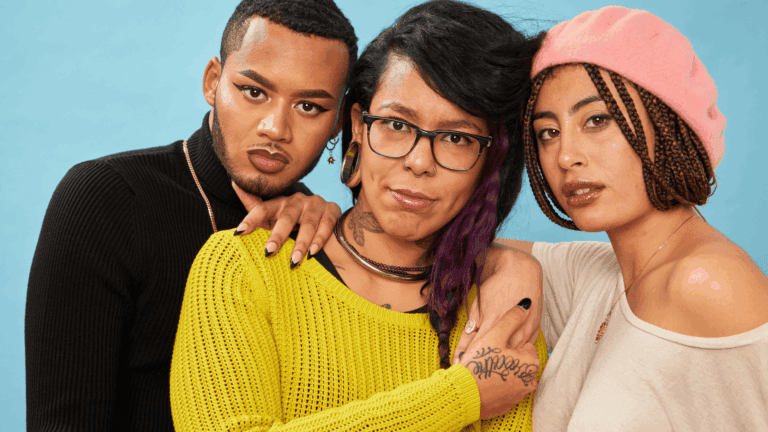 Three individuals standing together with their arms around each other, looking straight at the camera. The image radiates strength, solidarity, and pride, highlighting the beauty of inclusivity and community.