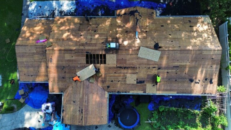 Drone view of a roof tear-off in Mint Hill, NC with damaged decking being replaced