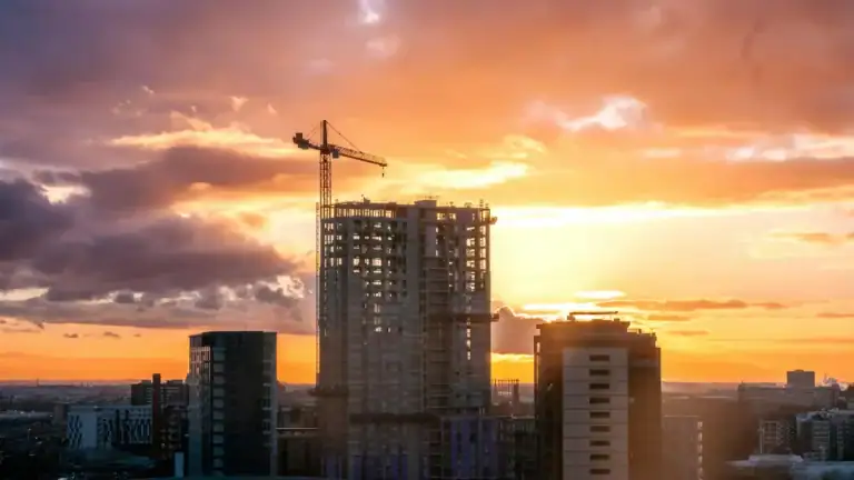 Edificio en construcción con grúa al atardecer representando defectos de construcción en vivienda de obra nueva y posibles reclamaciones legales en Zaragoza