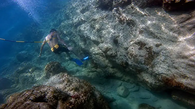 SNUBA participant exploring a rocky underwater landscape in St. Maarten