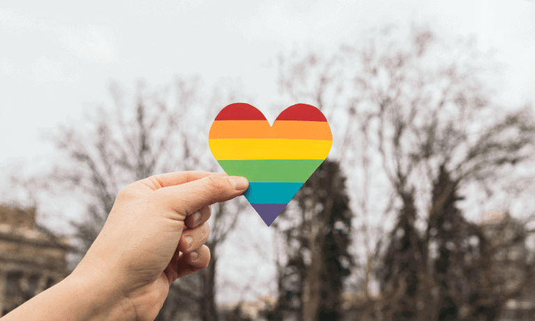 hand holding a rainbow heart as a sign of inclusivity