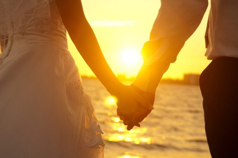 This image shows a couple walking together holding their hands