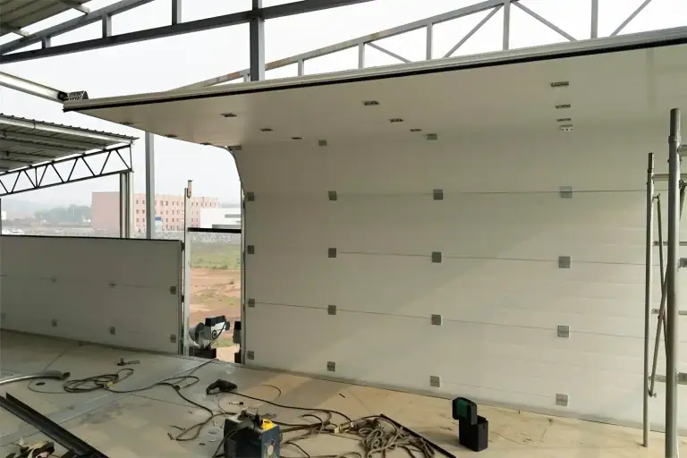 On-site installation process of an ABX heavy-duty commercial overhead door in an industrial facility, following strict manual tolerances to maximize MTBF and operational uptime.