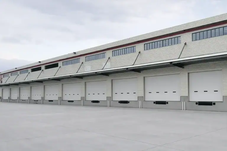 A row of high-performance industrial sectional doors installed at a large-scale logistics hub, showcasing ABX's custom-sized and CE-certified access solutions.