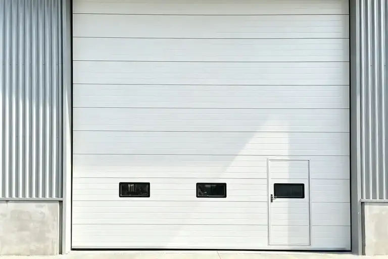 Heavy-Duty Industrial Sectional Overhead Door with Integrated Wicket Door and Vision Panels Installed in Cold Storage Facility