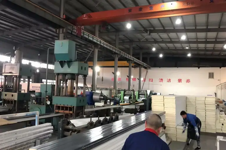 Heavy machinery and production line manufacturing high-density PU sandwich panels at the ABX wholesale insulated sectional doors factory, ensuring high capacity and competitive steel sectional door prices.