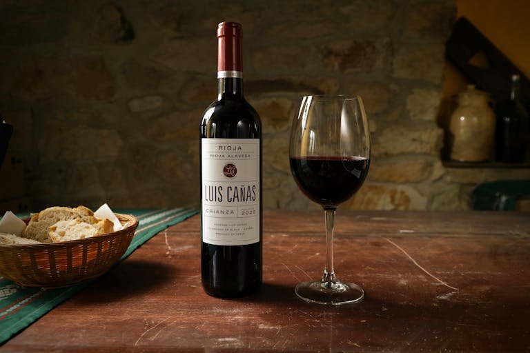 Bread loaf and wine goblet arranged on a table with warm lighting representing communion elements