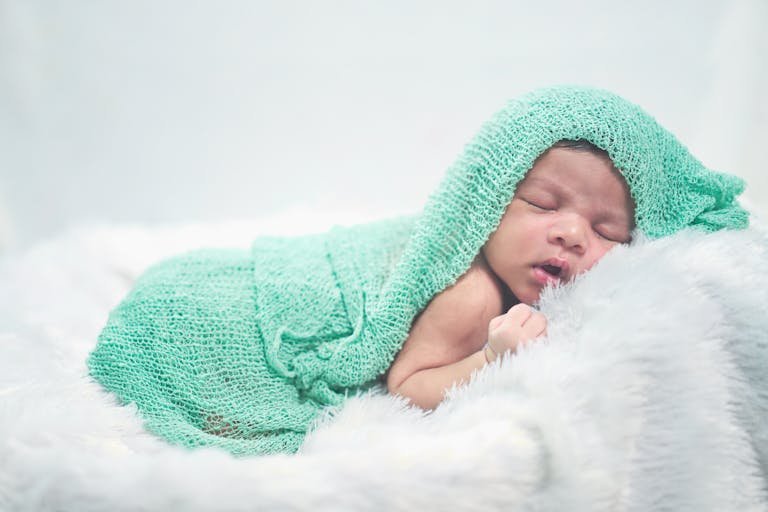 Serene newborn baby peacefully wrapped in soft white blankets