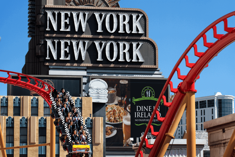 the roller coaster in front of a building with sign New york New york