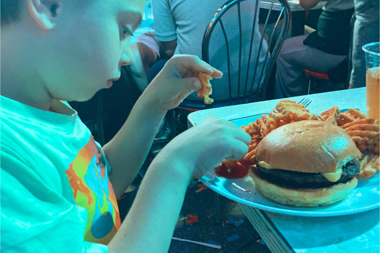 Child eating a burger at Ellen's stardust in NYC