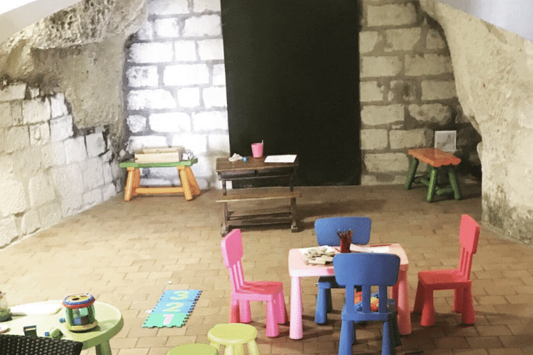 Playroom in Veuve Amiot's cellar with small colorful chairs, toys and crafts on tables