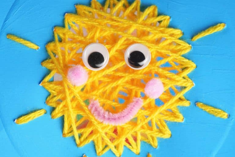 sun yarn craft on a blue paper plate