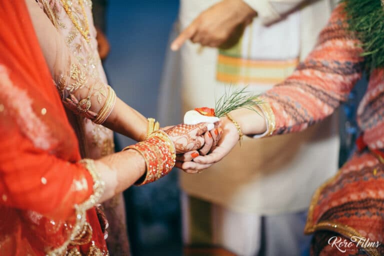Close-up of the couple’s hands joined with offerings during the Nepali wedding ritual in Pattaya