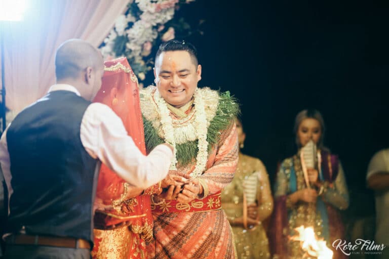 A relative holds the groom’s hands to bless him after the Nepali wedding ceremony in Pattaya