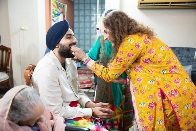 A relative blesses the Sikh groom during his Maiyan at home in Bangkok
