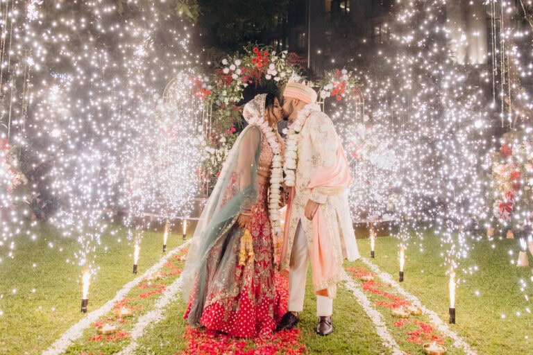 Shefali and Mohammed embrace between cold-spark fountains at their wedding at Siam Kempinski Hotel Bangkok