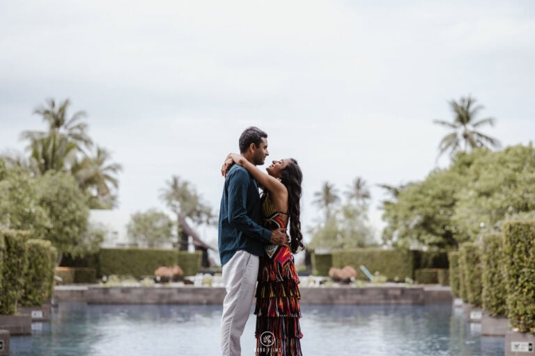 Tarun and Sasha embrace beside a palm-lined pool at JW Marriott Khao Lak