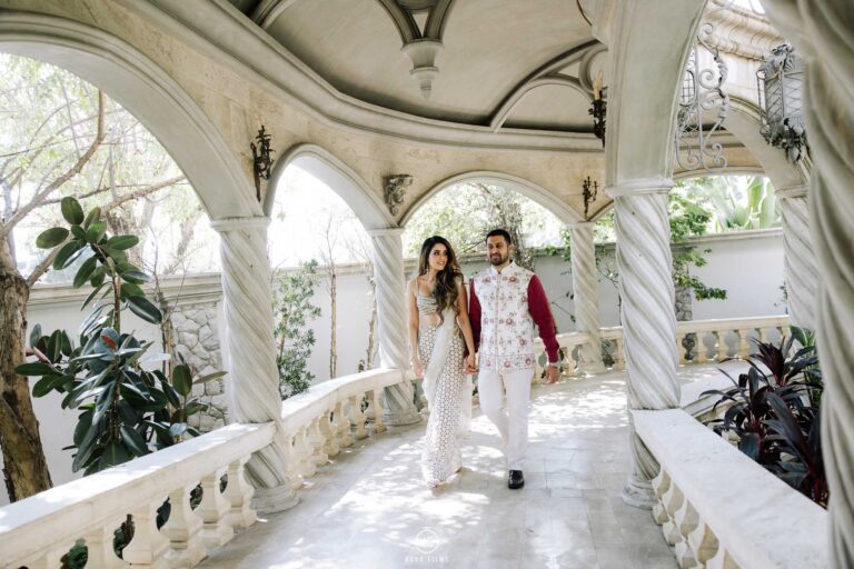 Devraj and Sanjana walk through a white arched colonnade at La Chapelle, Bangkok