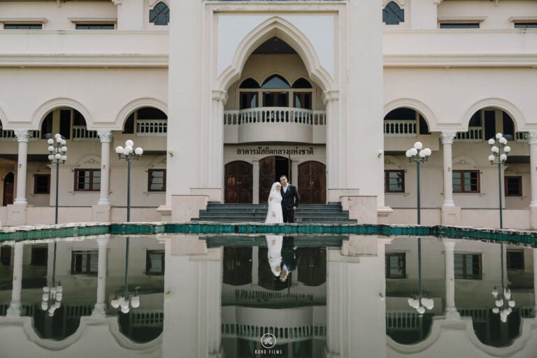 Bride and groom reflected in the pool in front of the Sheikhul Islam Office in Bangkok after their Nikah