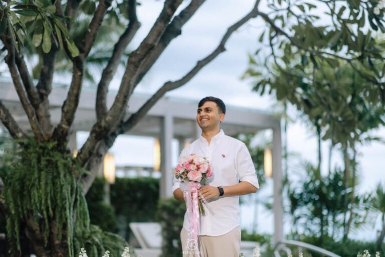 Vatsal waits in the garden with a pink rose bouquet before his proposal in Hua Hin