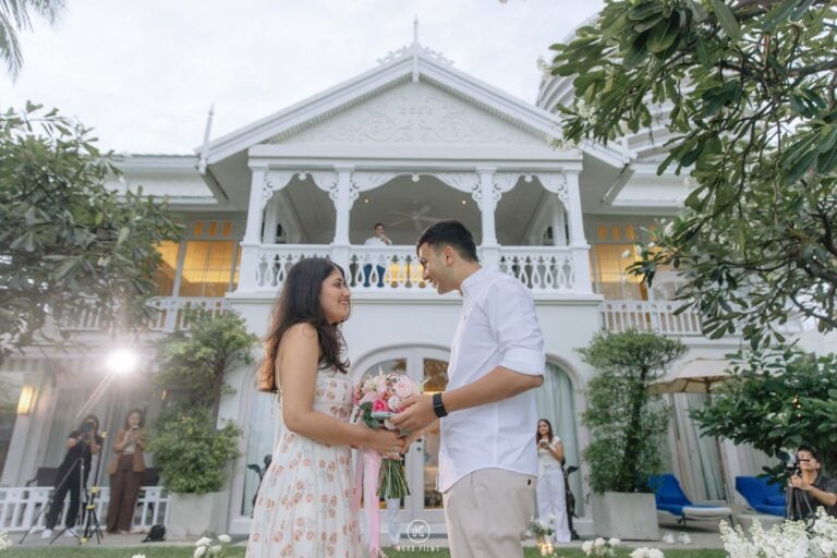 Vatsal gives Paridhi a bouquet in front of the white colonial villa at InterContinental Hua Hin