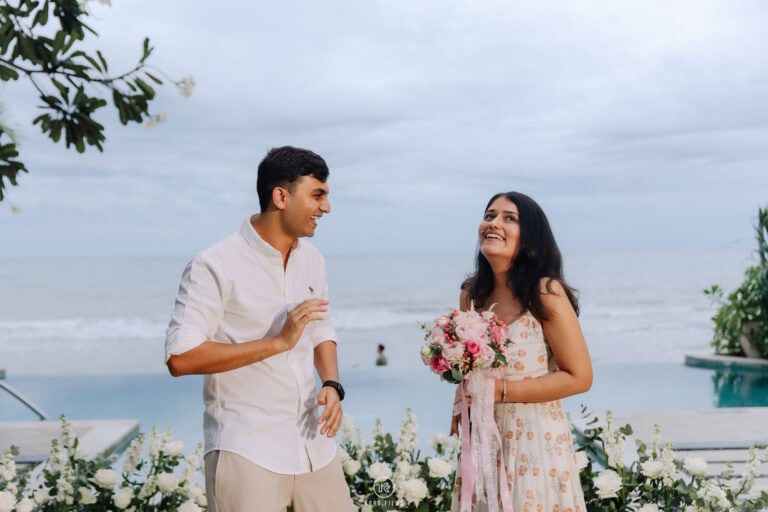 Paridhi laughs with her bouquet as Vatsal smiles beside her by the sea in Hua Hin