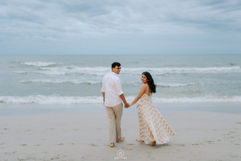 Vatsal and Paridhi walk hand in hand along the beach in Hua Hin after the proposal