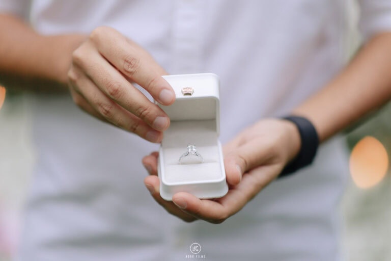 Hands hold an open ring box with a diamond engagement ring before the proposal in Hua Hin
