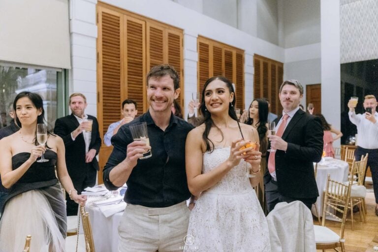 The bride and groom raise their glasses with guests at dinner after their Thai ceremony at The House on Sathorn, W Bangkok