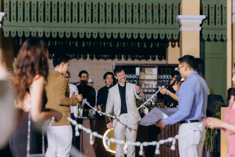 The groom and his friends face a garland chain held across the courtyard at the Thai door games at The House on Sathorn, W Bangkok