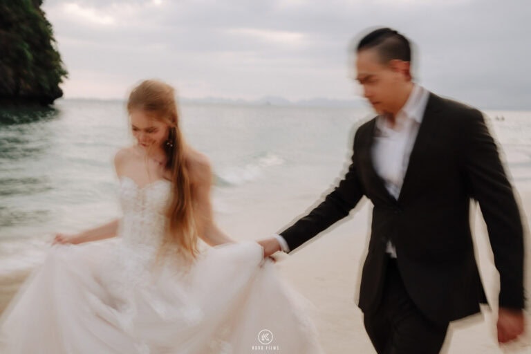Bruno leads Alessandra along the beach at golden hour at Rayavadee, Krabi