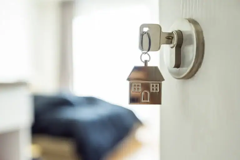 Llave en cerradura con figura de casa simbolizando el contrato de alquiler de vivienda y la figura del arrendador gran tenedor en la normativa vigente