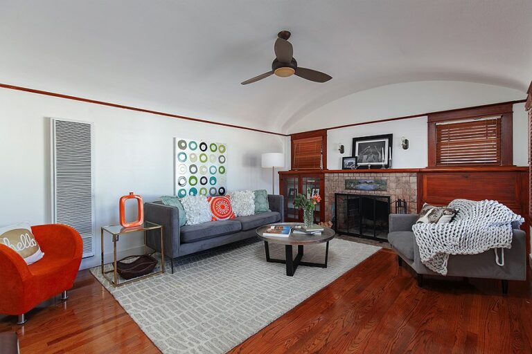 Grey sofa and bright accessories in light colored living room are great home staging ideas