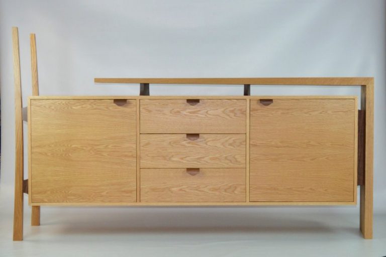 Made for a customer who wanted something different as when she was shopping around found most of the cabinets, she was looking at were just large rectangles. The design started as just a concept drawing which she like and we when from there. The use of the black walnut in the bent laminated handles and supports was chosen to match the flooring in her house. As part of the brief, she wanted something that didn’t look like something she had bought from a shop. The mitered thought dovetail was to give the piece a handmade feature and with the shape of the legs to the tapers and angles in the shelf for the subtle and elegant design which make this feature piece stand out but keeps usability and storage.