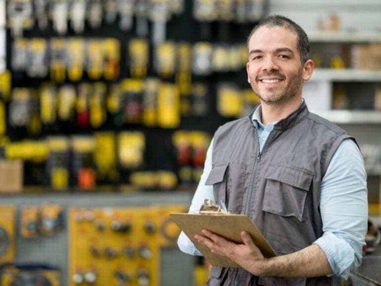 Hardware store owner standing with clipboard