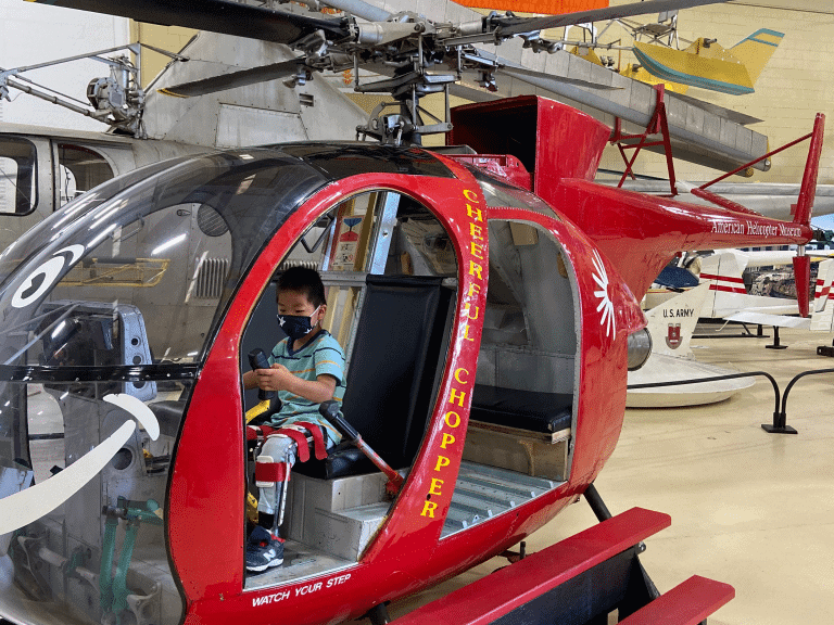 Little boy wit leg braces inside of an helicopter