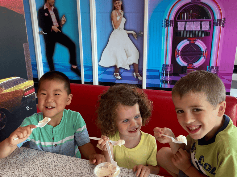Kids eating ice cream on retro booth smiling