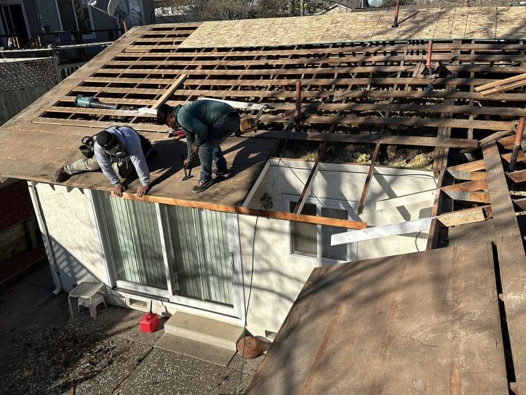 Two workers working on a roof