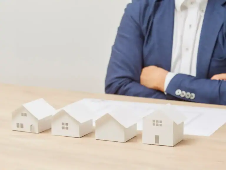 Maquetas de viviendas sobre mesa representando la gestión de rentas inmobiliarias a través de una sociedad patrimonial y su análisis fiscal