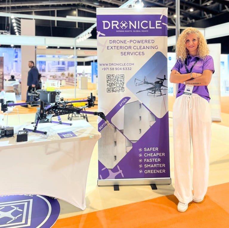 DRONICLE CEO Ozge at the Verti Expo with her booth and ad panel