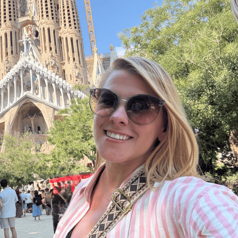Woman smiling in front of Sagrada Familia in Barcelona, Spain.