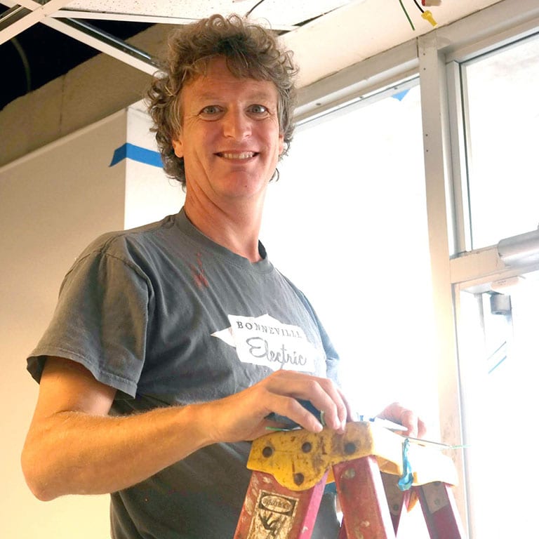 Smiling electrician on a ladder – Friendly electrical service by Bonneville Electric in Chapel Hill, NC