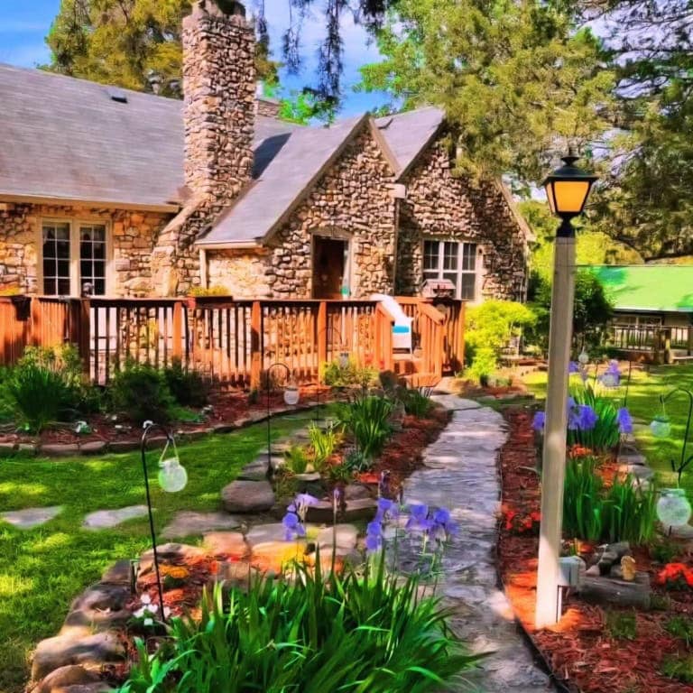 Charming stone cottage with lush garden and pathway in Eureka Springs, Arkansas.