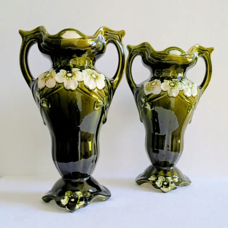 Paire de vases anciens en barbotine verte au décor floral en relief