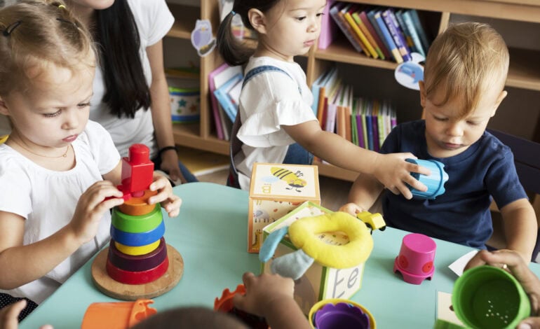 certibiocide désinfectants crèche. Enfants de maternelle jouant avec leur professeur dans la salle de classe